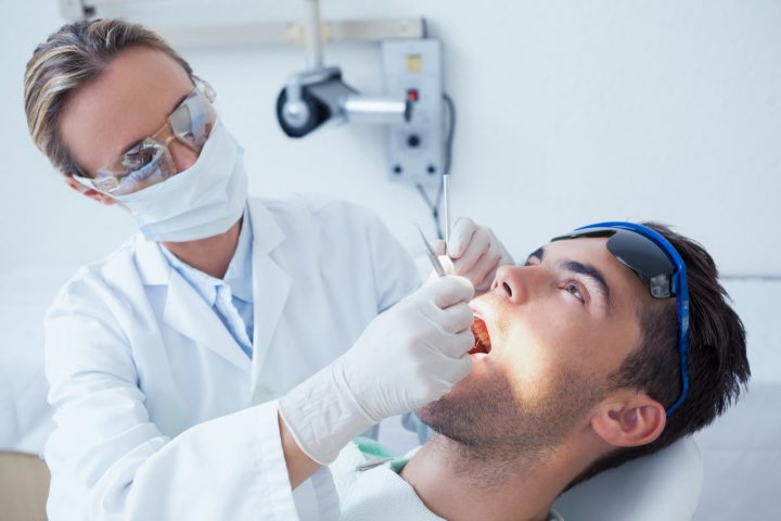 image of man in dentist chair having tooth extracted